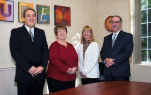 Photo of Gilbert Insurance Agency team members standing around table