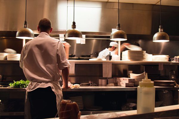 A photo of a restaurant kitchen with chefs hard at work - Restaurant Insurance in Greater Boston & Massachusetts