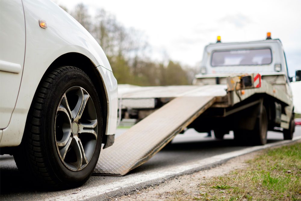 Photo of a car about to be loaded onto the tow truck