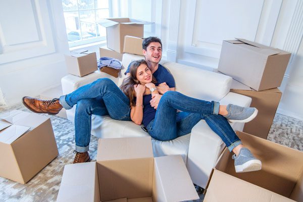 Photo of a couple relaxing while unpacking boxes - Renters Insurance in Greater Boston & North Shore MA