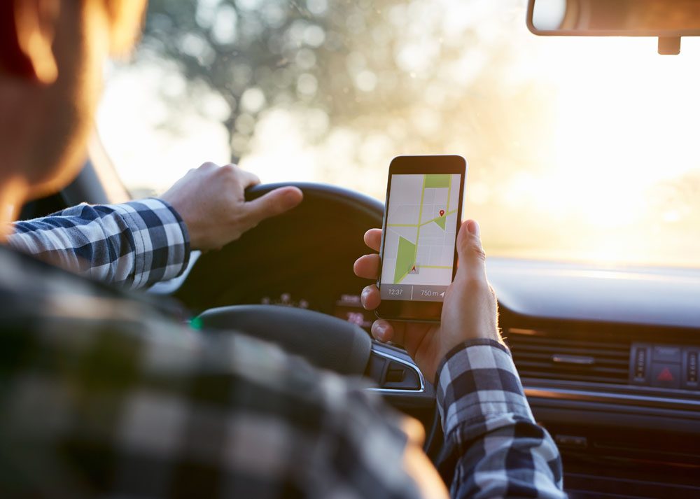 Photo of person holding cell phone while driving