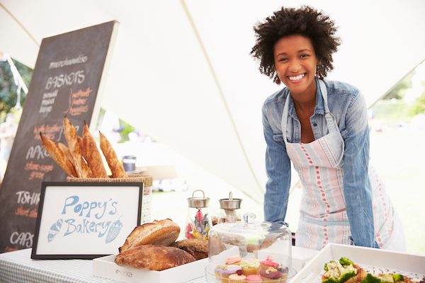 Photo of a woman smiling behind pastries, used for Small Business Insurance in Massachusetts page