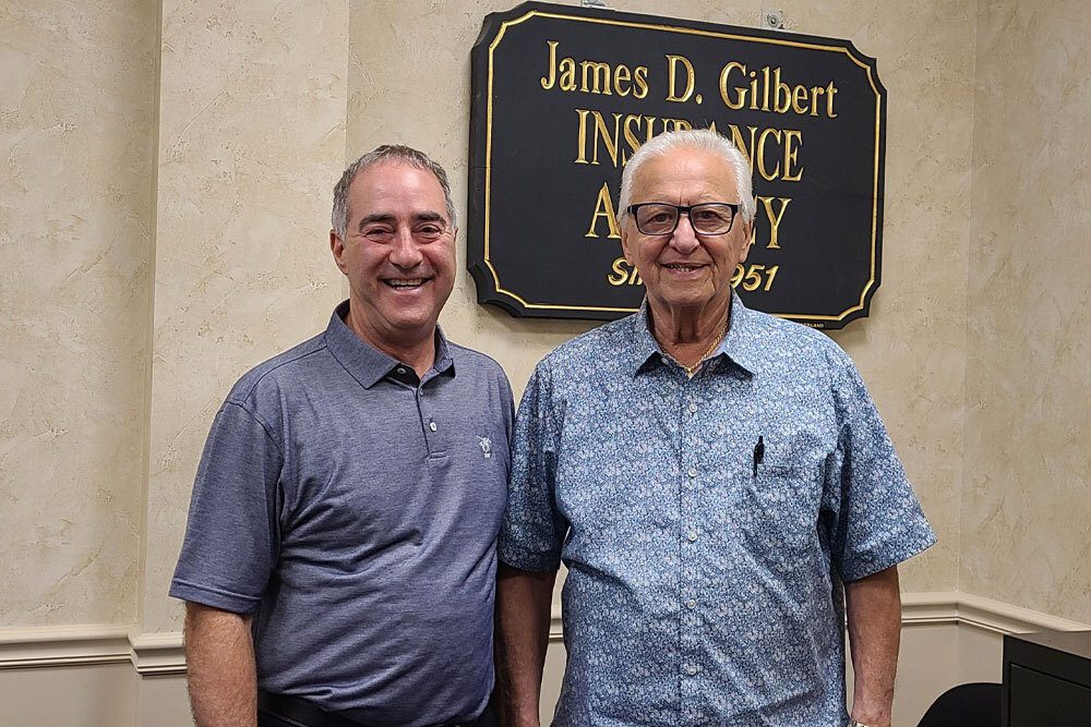 Photo of Mark Gilbert and Paul Schepis announcing the merger of their two insurance agencies